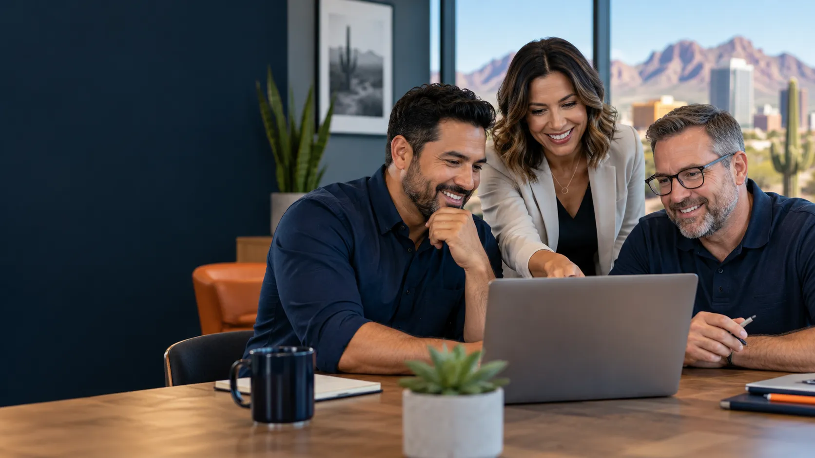 Two business owners and an advisor reviewing a website together on a laptop.